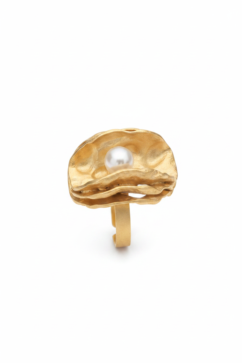 Anillo dorado con perla sobre fondo blanco