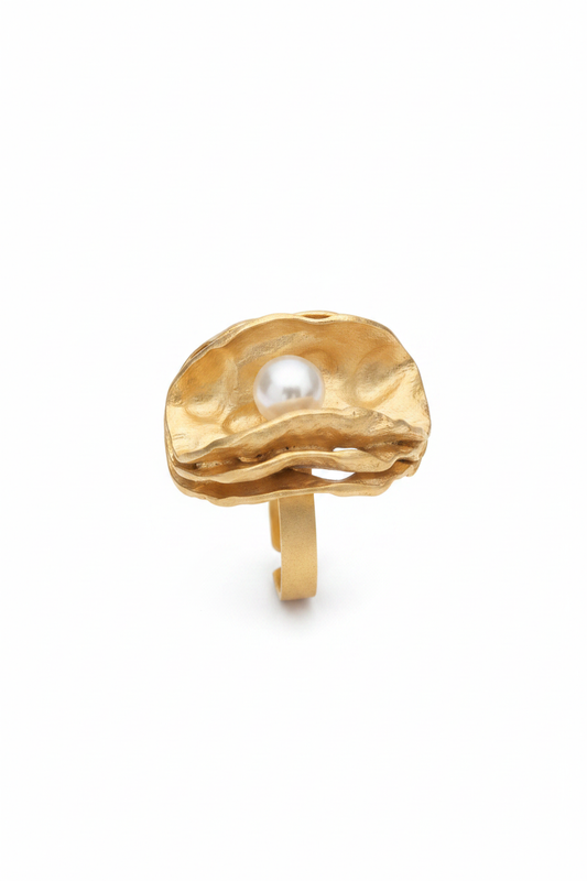Anillo dorado con perla sobre fondo blanco