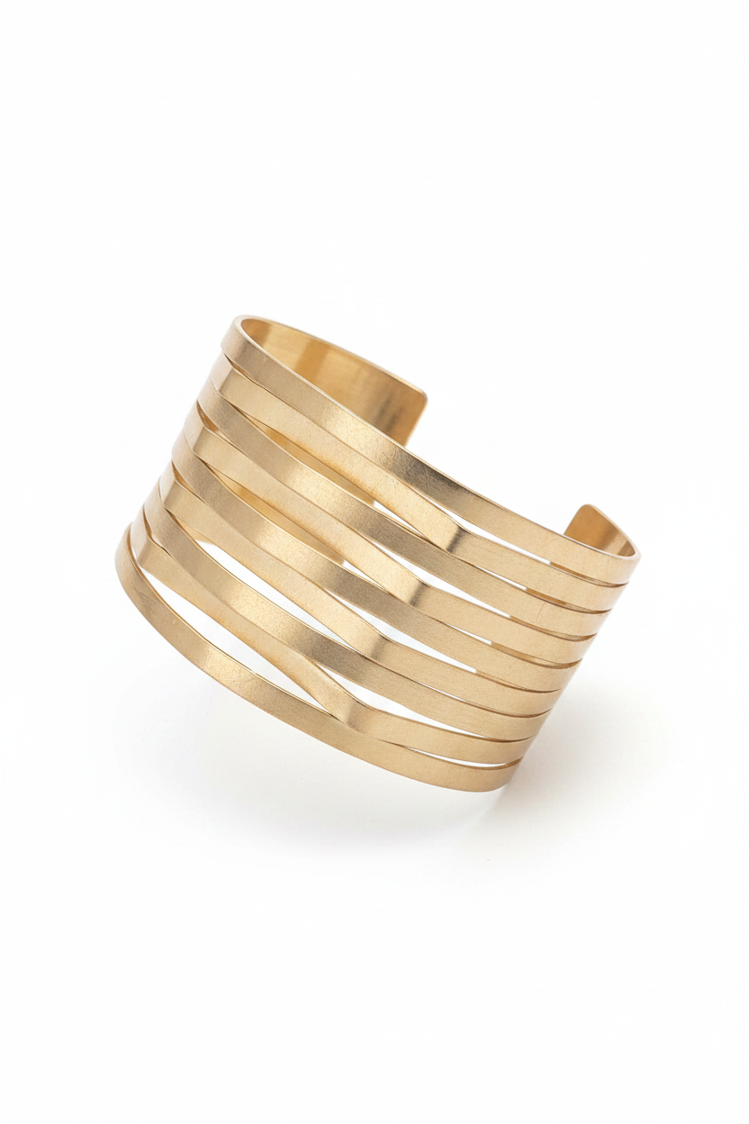 Pulsera dorada ancha con líneas diagonales sobre fondo blanco