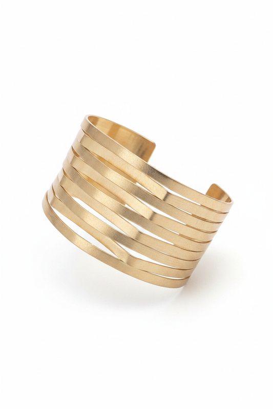 Pulsera dorada ancha con líneas diagonales sobre fondo blanco