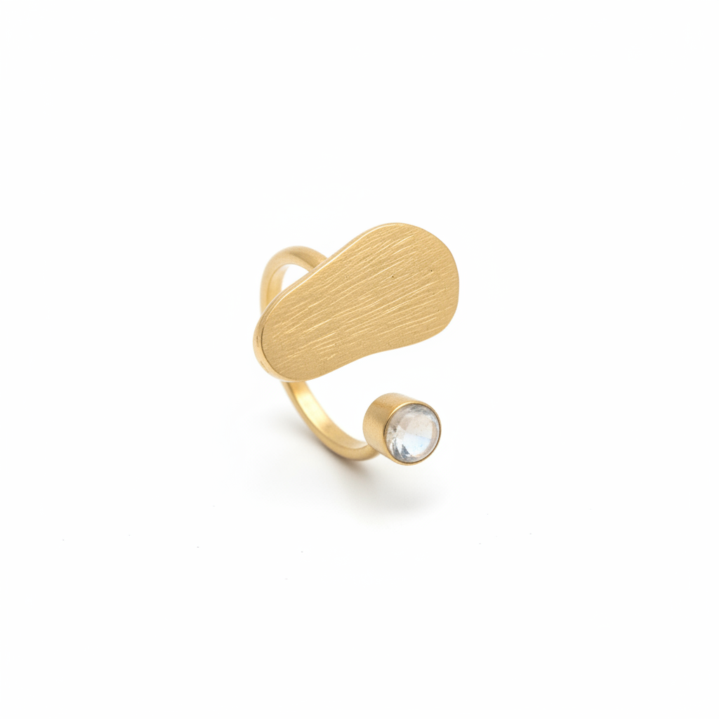 Anillo dorado con piedra lunar sobre fondo blanco