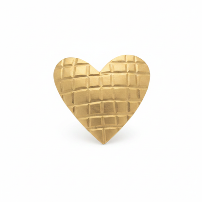 Anillo corazón dorado con textura de cuadrícula sobre fondo blanco