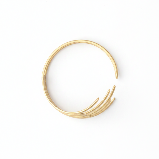 Pulsera dorada geométrica con barras paralelas sobre fondo blanco